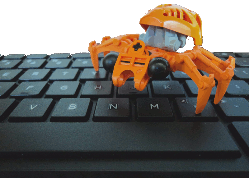 Image: A bright orange Bionicle spider standing on a computer keyboard, looking down at it.